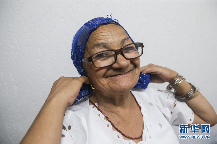 为巴西狂欢节缝制服装的老妇人