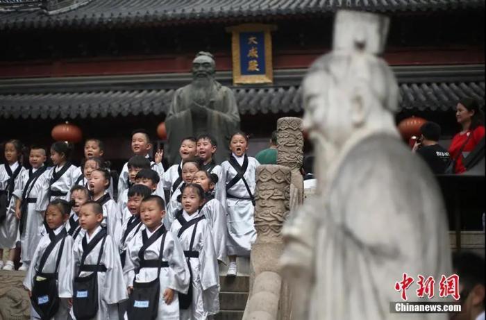 资料图：南京小学生行古礼点朱砂“开笔破蒙”，孩子们在南京夫子庙大成殿内的孔子像前留影。泱波 摄