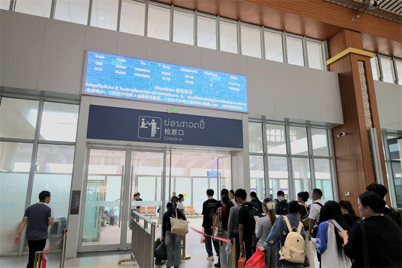 中老铁路首开早间磨丁至万象城际列车 乘客在老挝磨丁检票口有序排队等候上车。老中铁路有限公司供图